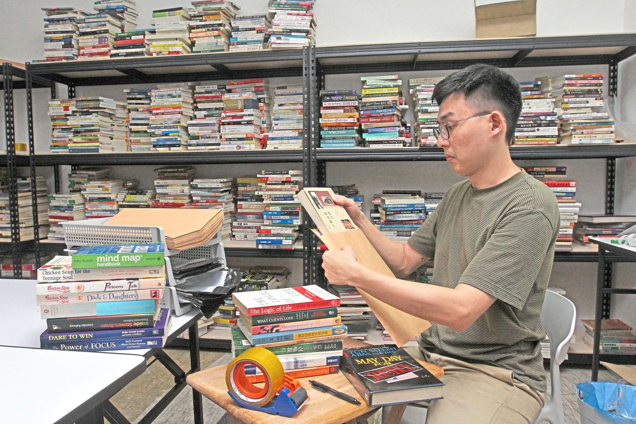 Chung of Loteng Bookstore, at his warehouse in Jalan Helang, packing orders to be shipped to customers.