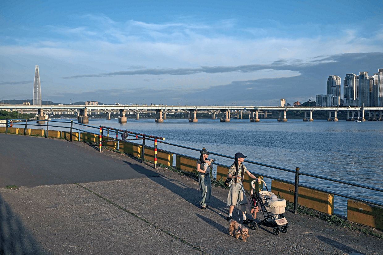 Darkness beneath the calm: People walking along the Han River in Seoul. Despite its beauty, it is also a frequent scene of despair in a country with one of the world’s highest suicide rates. — AFP 