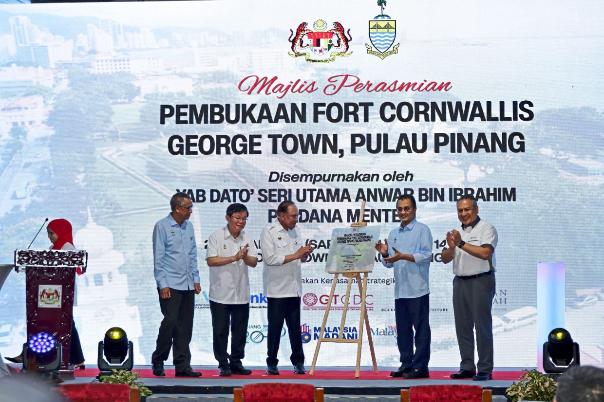 Anwar (centre) at the signing of the commemorative plaque to open the newly restored Fort Cornwallis, together with Chow (second from left) and other distinguished guests.