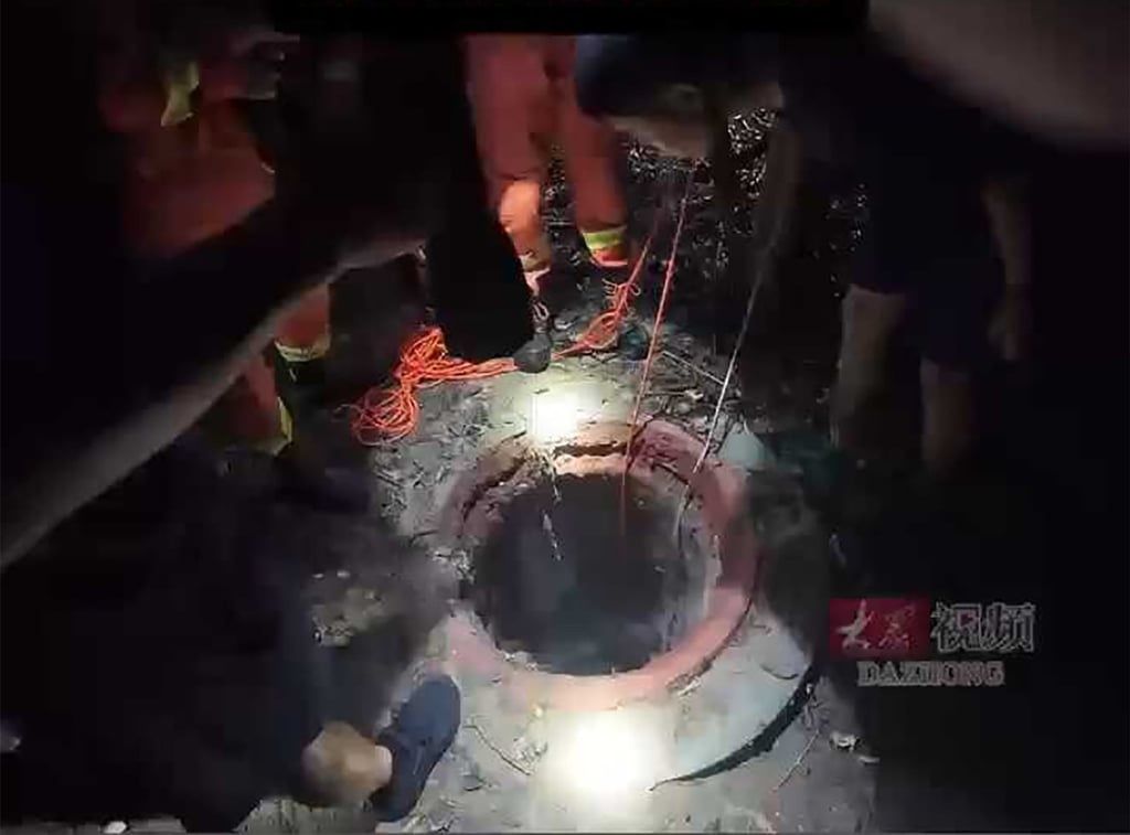 The woman sustained injuries from the fall and was unable to move inside the well; both were eventually safely lifted out of the shaft by firefighters. - Photo: Yangcheng Evening News