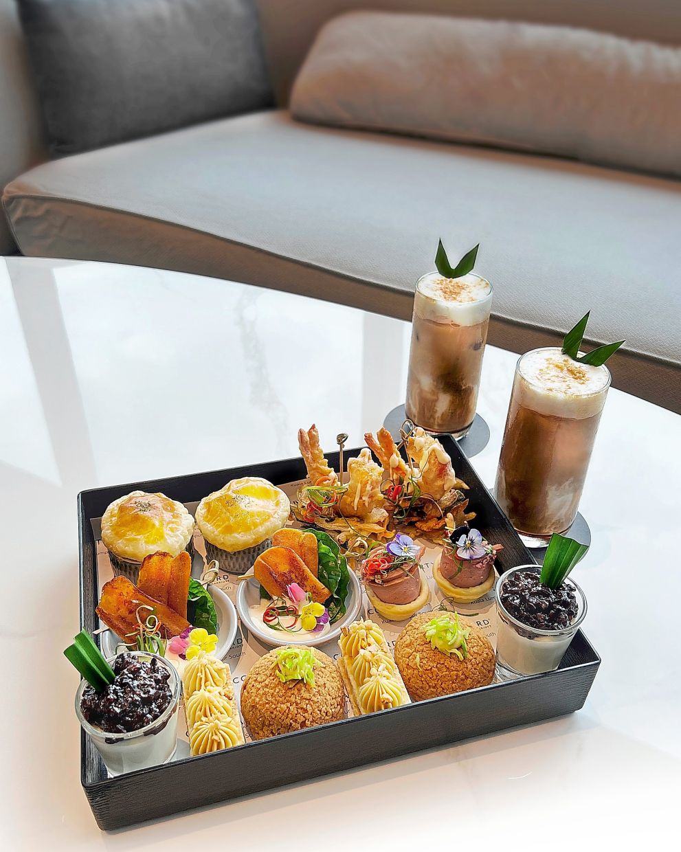 Afternoon Tea Bento at Courtyard Lounge showcases local sweet and savoury delicacies.
