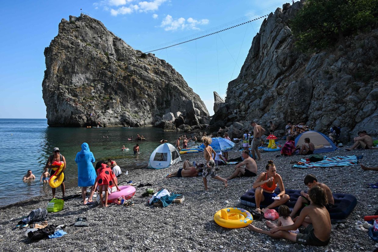 Tourists sunbathing on a beach in Simeiz. — AFP