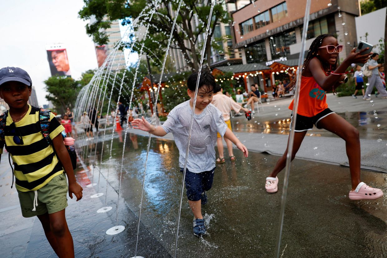 Children playing in a fountain to cool off during a heatwave in Seoul, South Korea on July 31, 2026.- Reuters