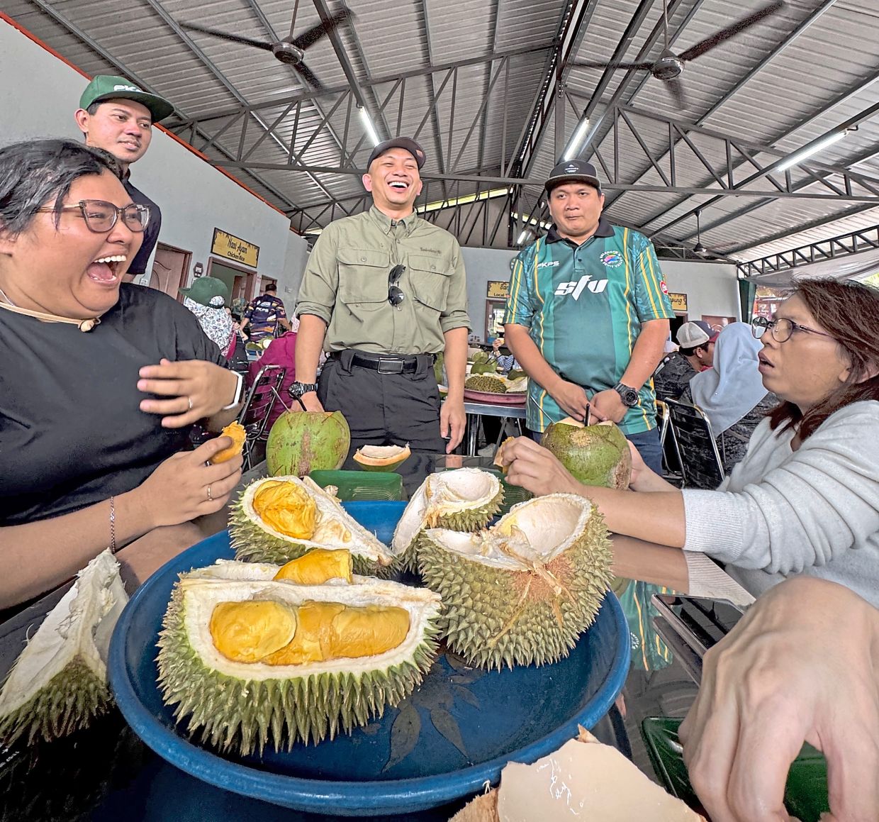Visitors having fun during a durian-tasting session while chatting with (standing from left) PKPS head of public relations Iwan Shu-Aswad Shuaib, Mohamad Khairil and Raja Muhammad Faiz.