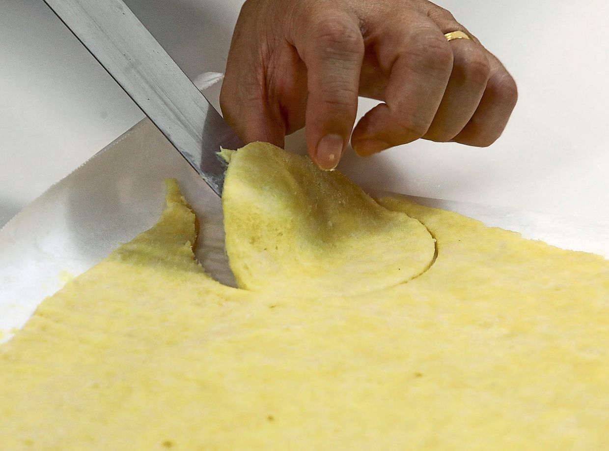 Using a 9cm cutter, cut out circles and press them gently into the muffin cups.