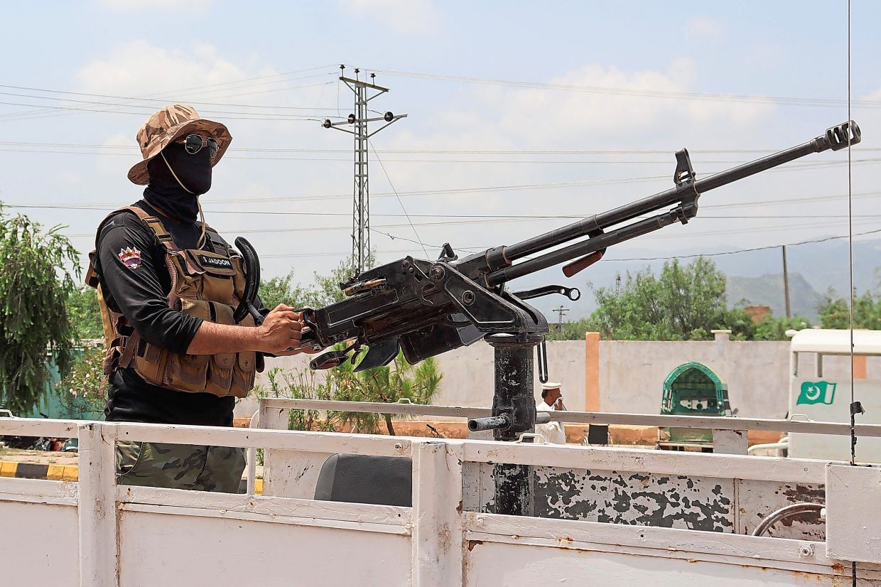 Insurgent strike: A security personnel standing guard after a militant attack on a checkpoint at Hangu district in Khyber Pakhtunkhwa province. Armed militants killed 11 and injured many others in the attack. — AFP/AP