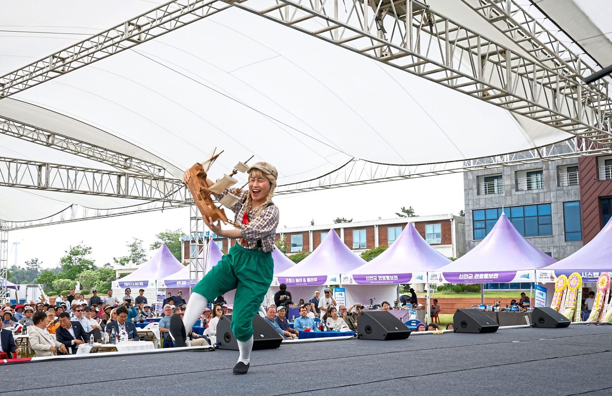 A performer dancing to a representation of the French whaler ‘Narwhal’ during a performance about its shipwreck during the third annual Champagne-Makgeolli Festival on Biguem Island. — Cho Woo-hae/The New York Times