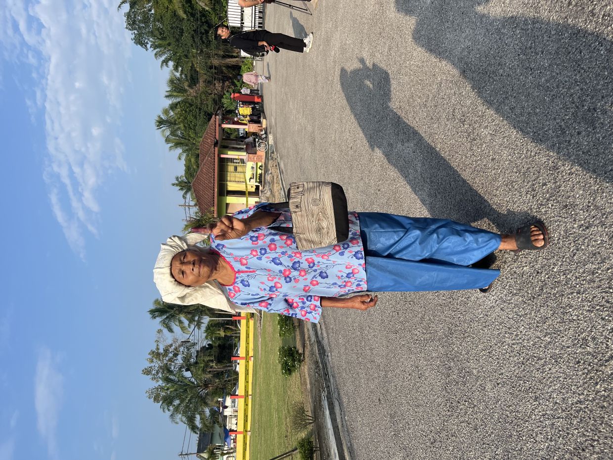 Mission accomplished. Ink on her finger and a smile on her face, Limah Ujang leaves the polling station after becoming one of the day’s early voters.
