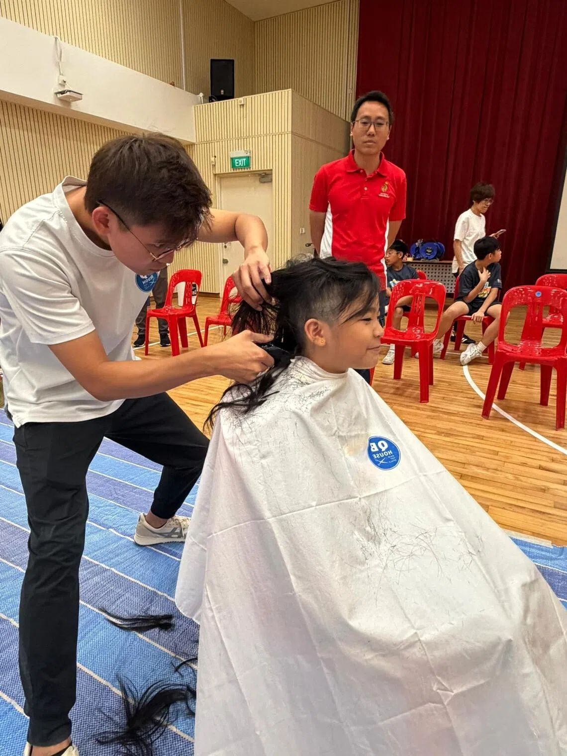 Primary 3 pupil Joy Ang, nine, having her hair shaved off at Kong Hwa School’s Hair for Hope event on May 22. - Photo: Antz Lee
