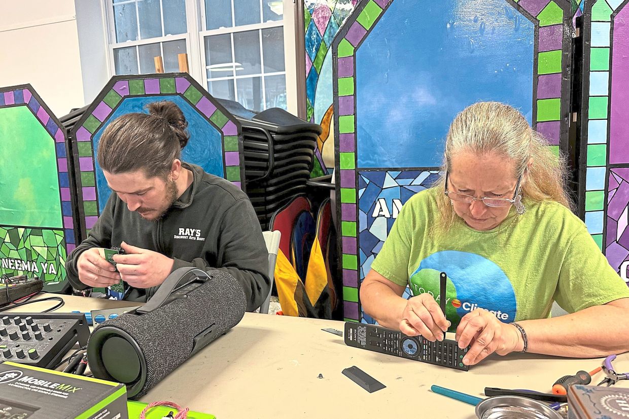Electronic repair coach Dan Casey (left) and his mother Diane Casey work on a sound-mixing device.