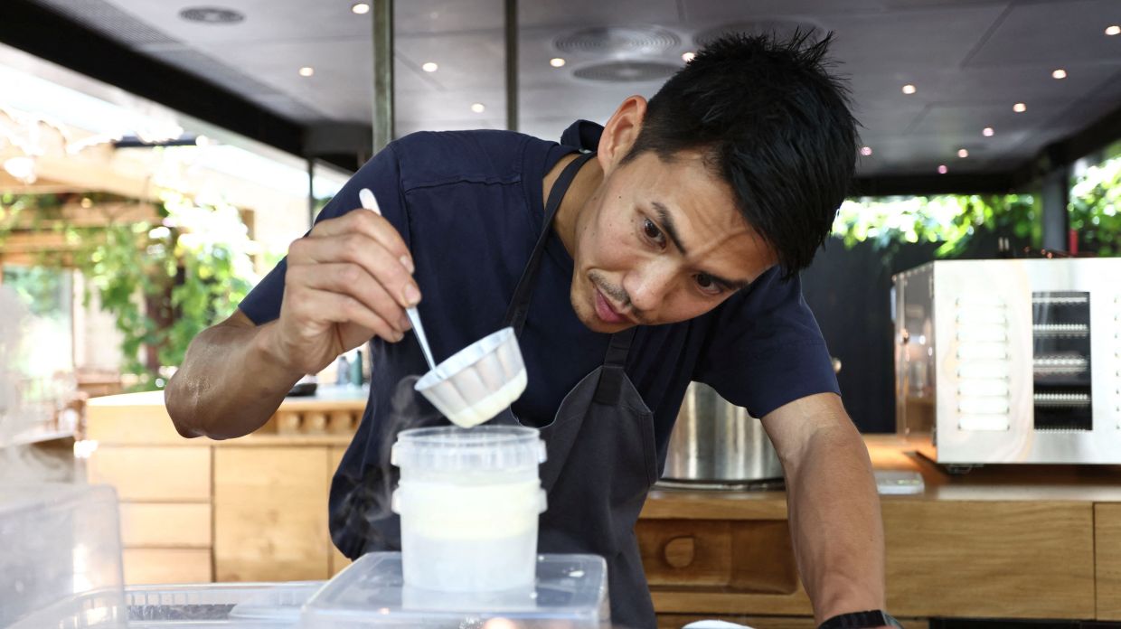 A member of staff at Noma practices preparing a dish in the kitchen ahead of the opening of the restaurant.