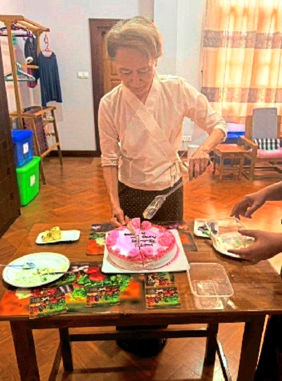 Suu Kyi cutting the cake at the meeting. — AP