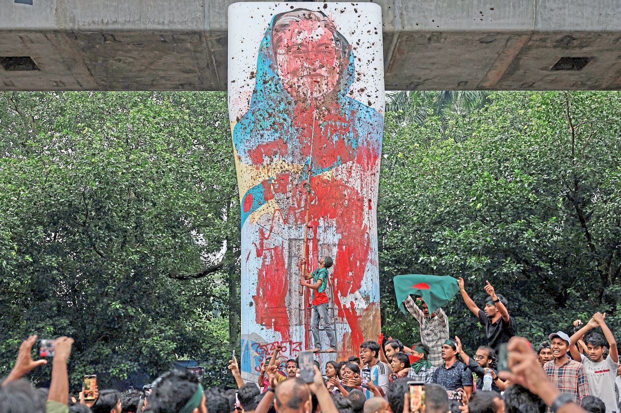 A file photo of protesters gathering as they vandalise a mural of Hasina with paint and mud, demanding her resignation at the University of Dhaka, on Aug 3, 2024. — Reuters