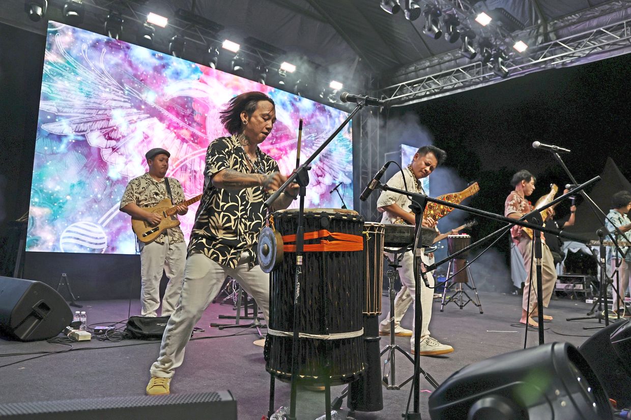 Sarawakian ethnic fusion band At Adau performing with traditional and contemporary musical instruments.