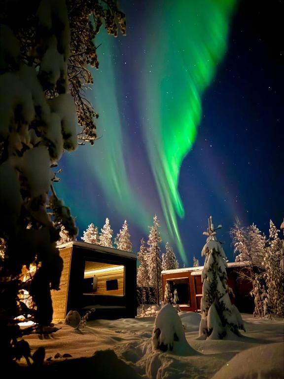 Spend an unforgettable Arctic night beneath a glowing sky at Aurora Hill Resort, Finland.