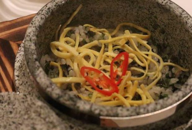 Namul Sotbap, featuring Calrose rice cooked in a Korean stone pot and topped with ribbons of omelette.