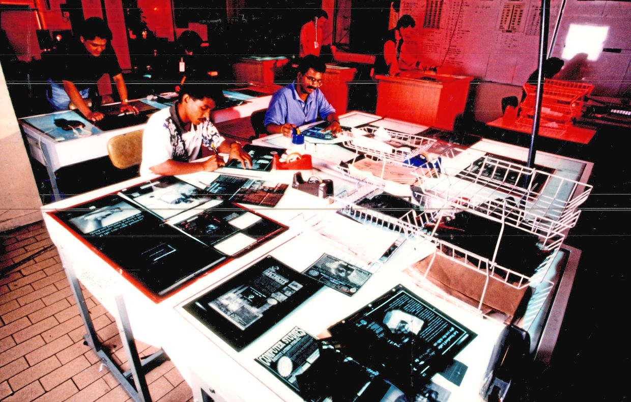 Staff in the mounting department prepare finished page layouts before they go to press.