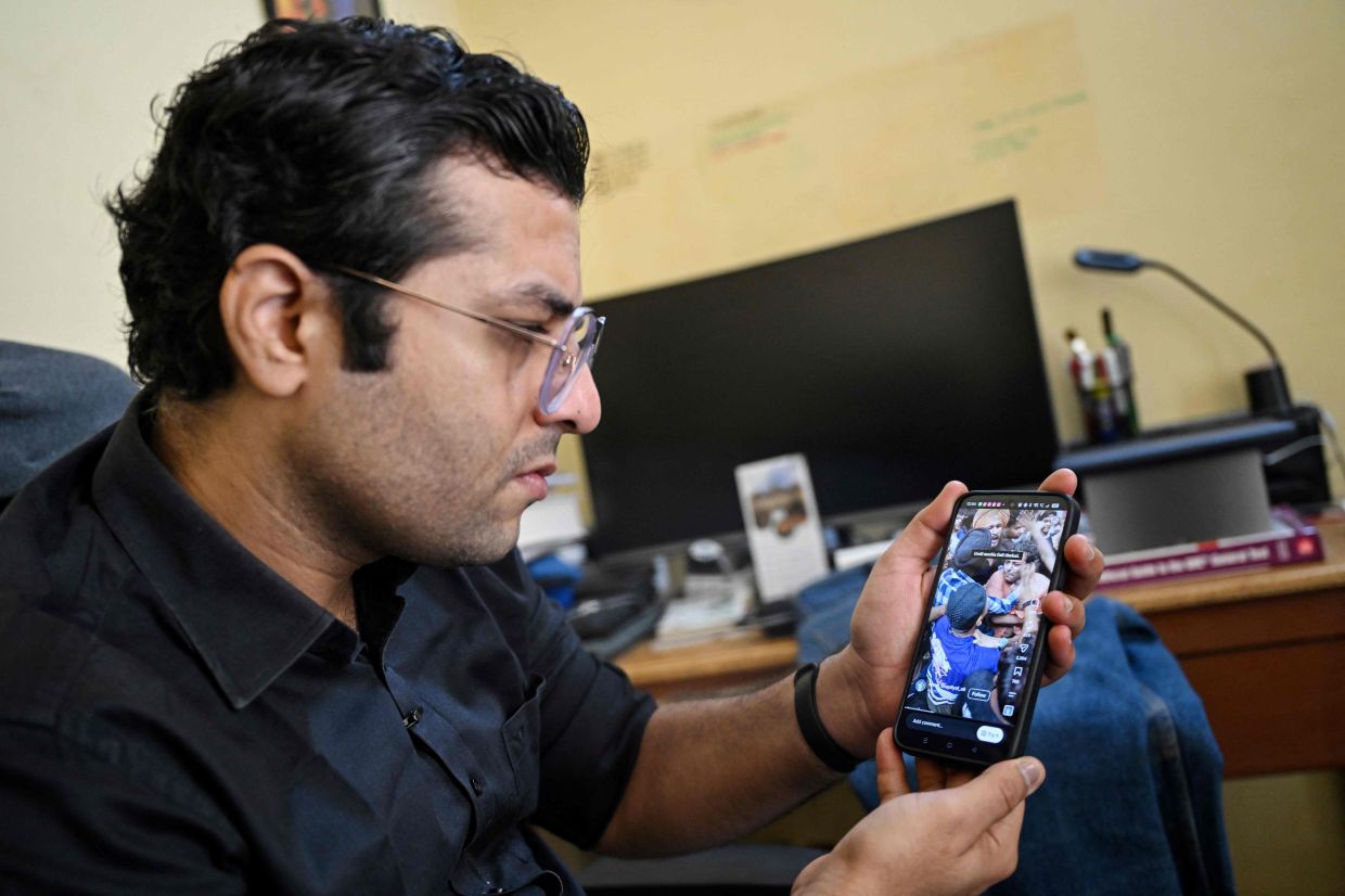 Prominent English-language TV network Times Now reporter Dev Kotak displaying a video of being attacked while covering student protests during an interview with AFP in Noida. - AFP