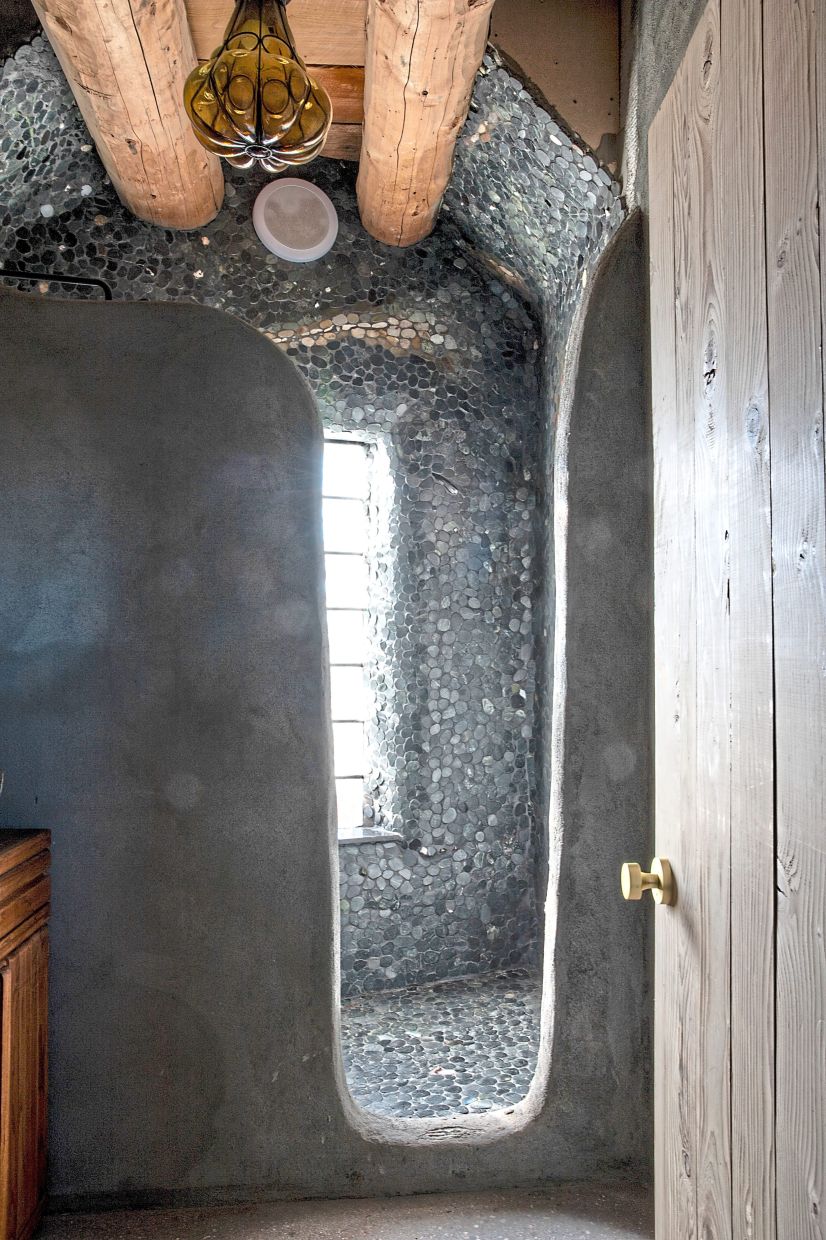 The bathroom shower, lined floor-to-ceiling with river rocks.
