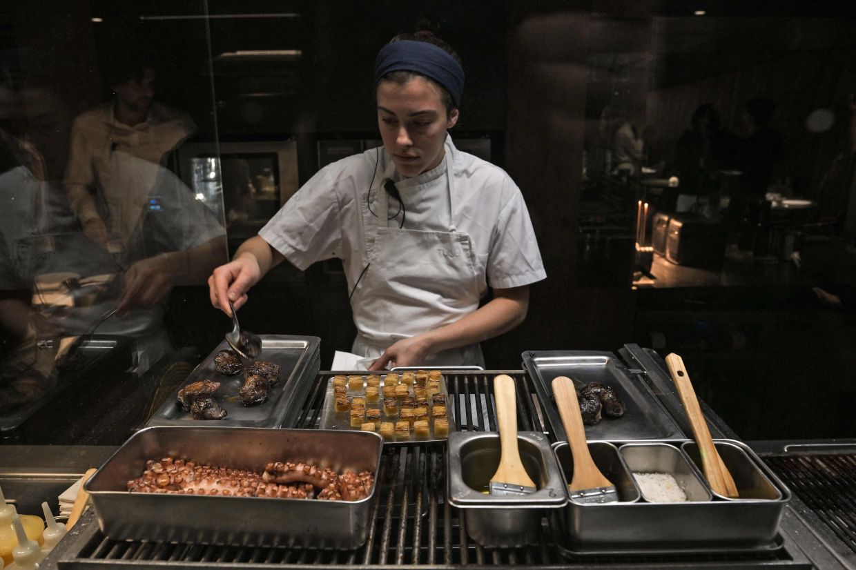 A cook works in the kitchen of the TUJU restaurant.