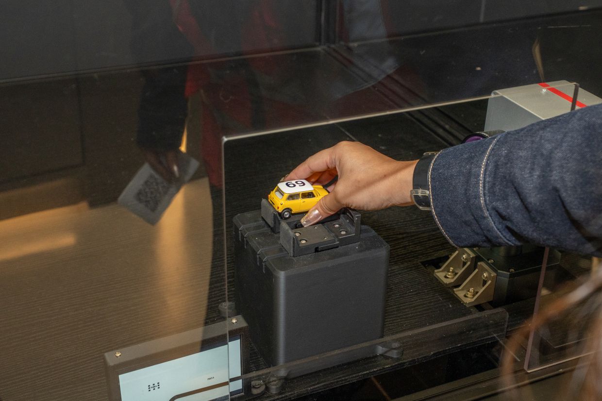 A guest experiences one of STEF's interactive production stations, where robotics and hands-on activities bring the miniature vehicle manufacturing process to life.