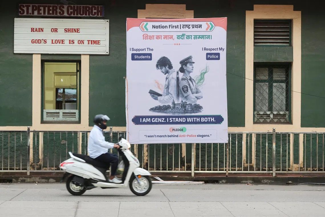A commuter rides a scooter past a hoarding depicting a student and a police officer along a pavement in Mumbai, India, Aug 5, 2026. - Photo: Reuters