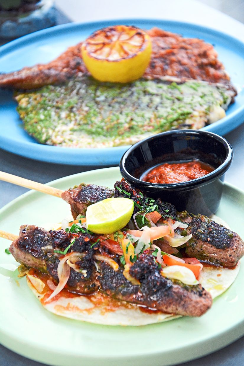 Charcoal-grilled Lamb Loin Skewers (front) and Baked Whole Baby Red Snapper.