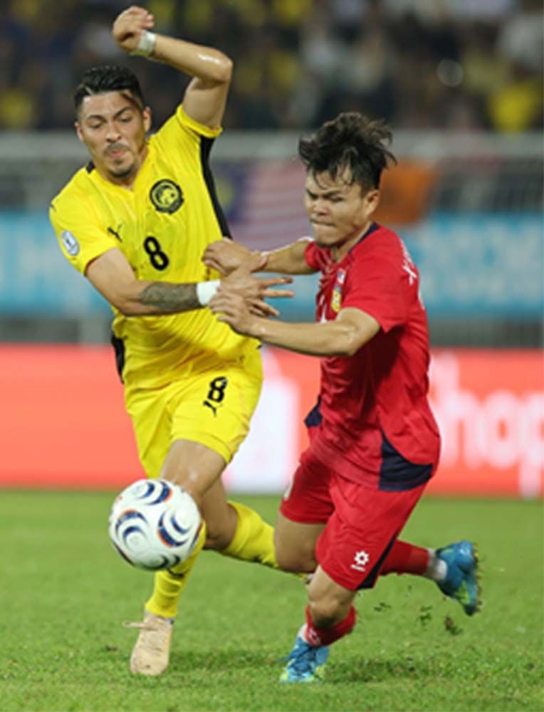 Experienced: Sergio Aguero (left) fighting for the ball with Laos’ forward Xayasith Singsavang during the Group B match of the AFF Hyundai Cup at the Kuala Lumpur Football Stadium on July 28. — GLENN GUAN/The Star