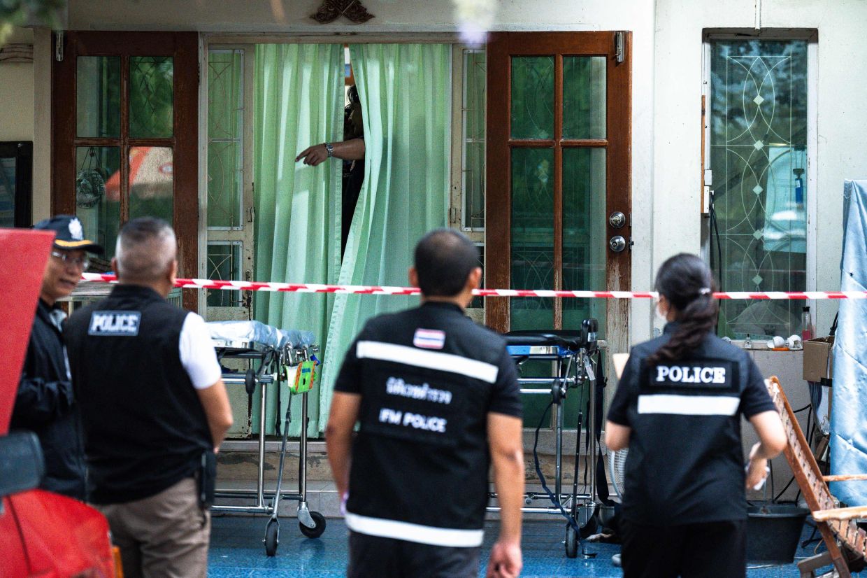 Police gather outside the house where a teenage suspect is suspected of killing his grandparents before carrying out a school shooting in Nonthaburi province, north of Thailand's capital Bangkok, on Friday, August 7, 2026. A teenage suspect killed his grandparents before shooting dead at least six more people at a school near Bangkok on August 7, police said. -- Photo by Chanakarn LAOSARAKHAM / AFP