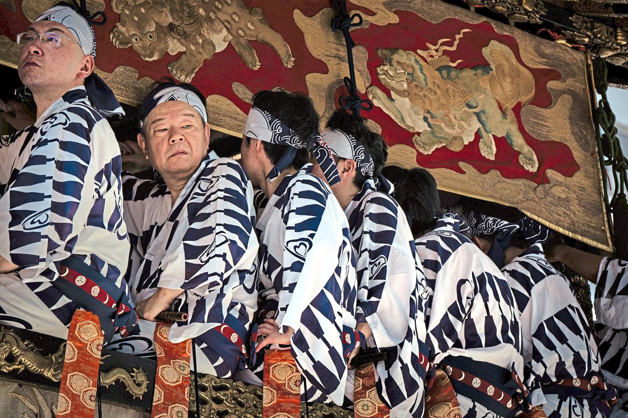 Warding off evil: Musicians are seen atop a festival float during one of the main parades of Shinto’s Gion Matsuri festival in Kyoto. — AP