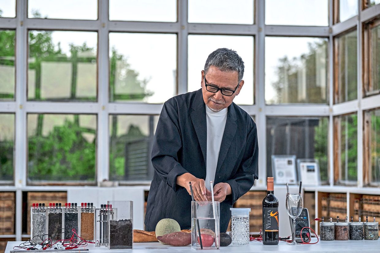 Satoshi Nakagawa demonstrating how to generate electricity using food, wine and other materials at the 'Ku-An' test lab in Hitachi-ota.