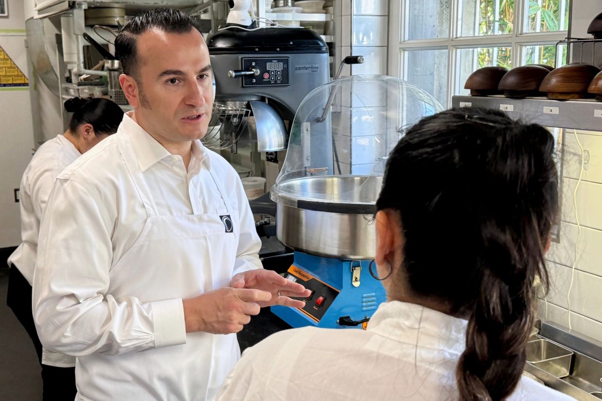 Chef Val Cantu, co-owner of Californios, speaks with a member of the staff .