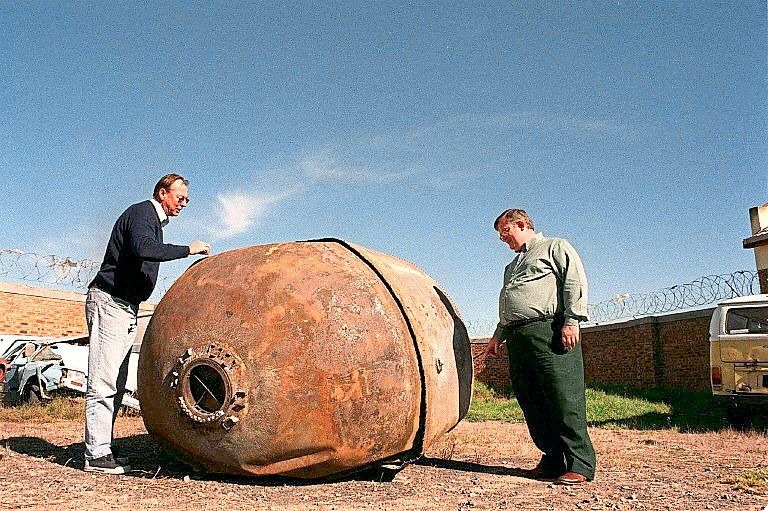 Astronomer David Laney (right) and education officer Case Rijsdijk of the South African Astronomical Observatory examine a piece of space junk at the Kraaifontein police station in Cape Town in May, 2000. — AFP