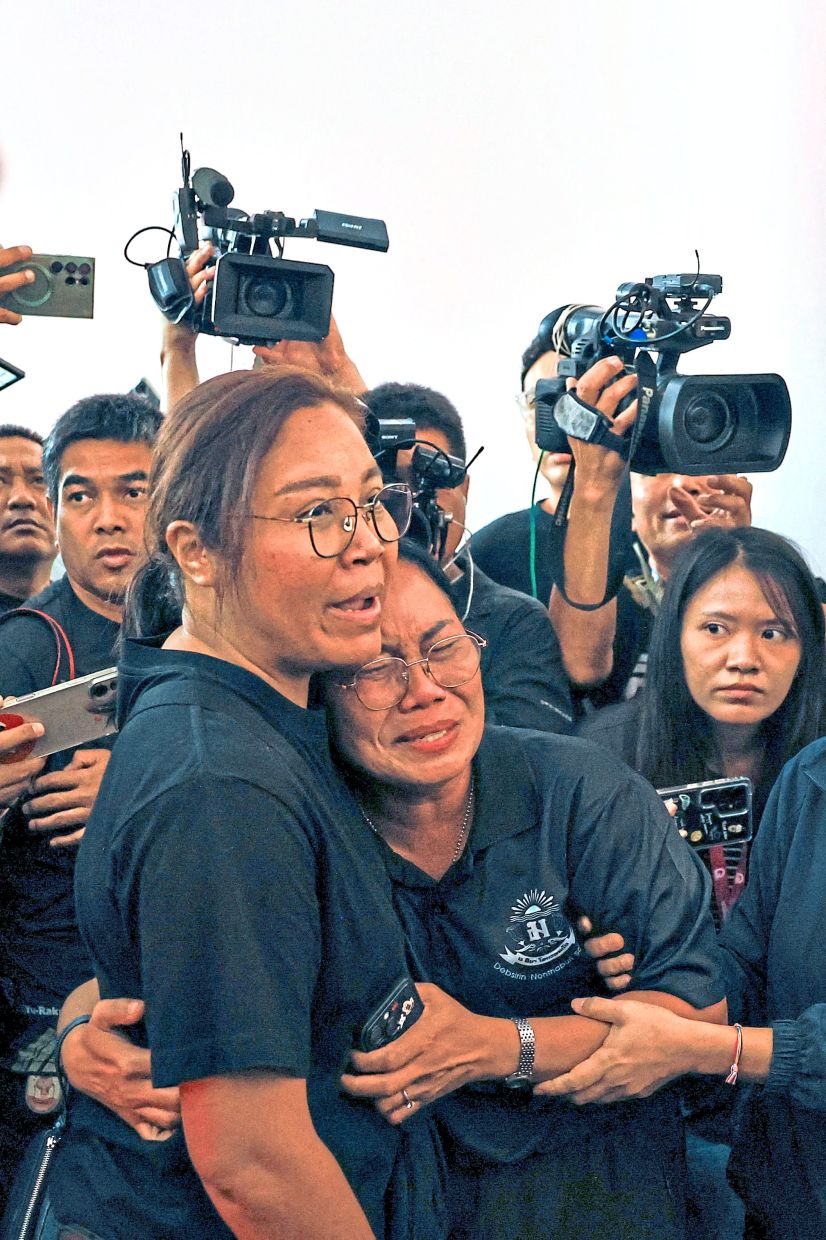 As grief takes hold: (From top) Family members of a teacher killed in the deadly shooting at Debsirin Nonthaburi School grieving as they receive his body at Police General Hospital in Bangkok;the slain teacher’s wife holding a framed photograph of him at the hospital; a Buddhist monk leading workers carrying a victim’s coffin; and mourners leaving flowers at the school gate. — Reuters/AFP