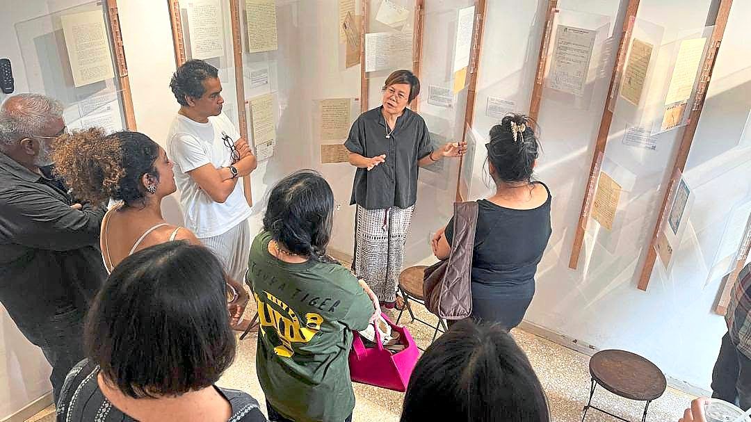 Lim (middle) gives visitors a guided tour of the exhibition, where 100 letters are displayed throughout the rooms and hallways of Papan Haus. Photo: Papan Haus