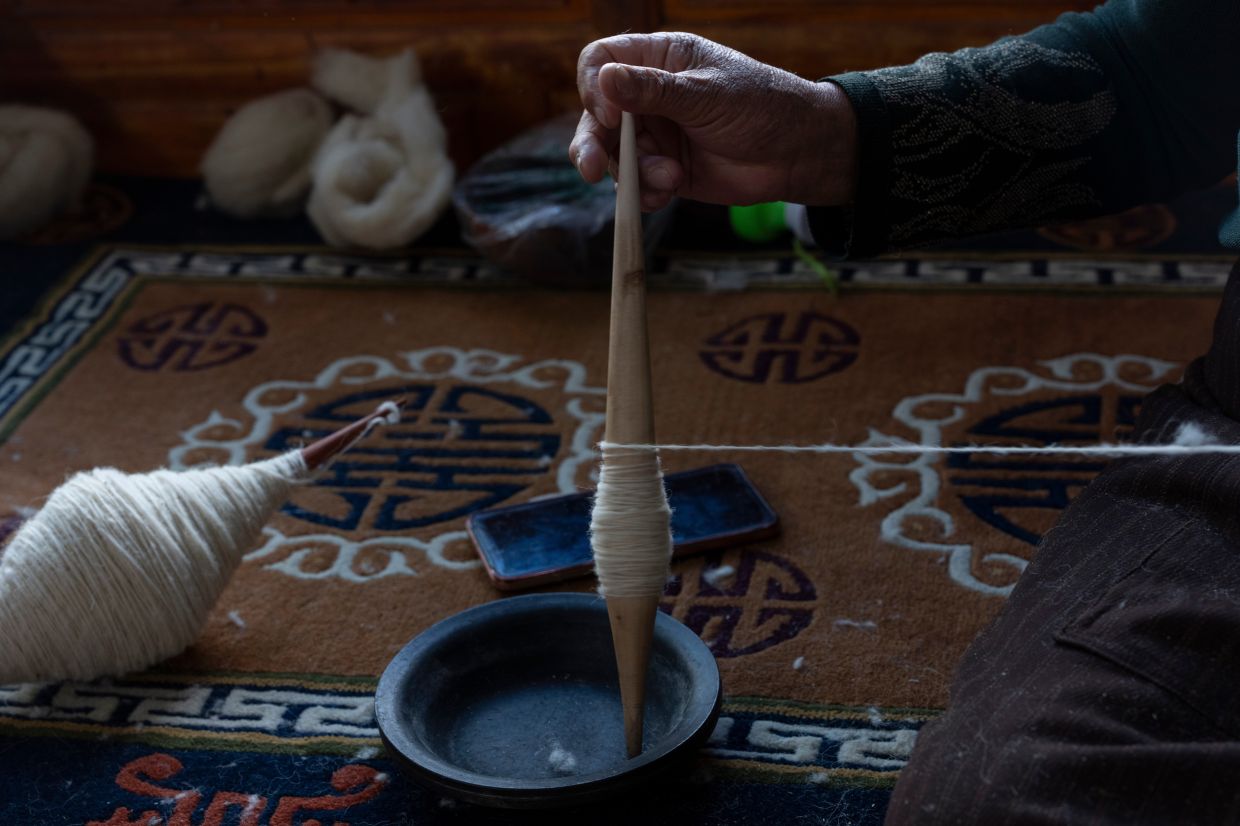 A worker pulls wool into a yarn at the Ethnic Huaji Handwoven Cooperative in Shannan in western China's Tibet Autonomous Region. Photo: AP 