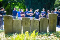 A cemetery becomes a classroom as youth tend to graves of fallen soldiers