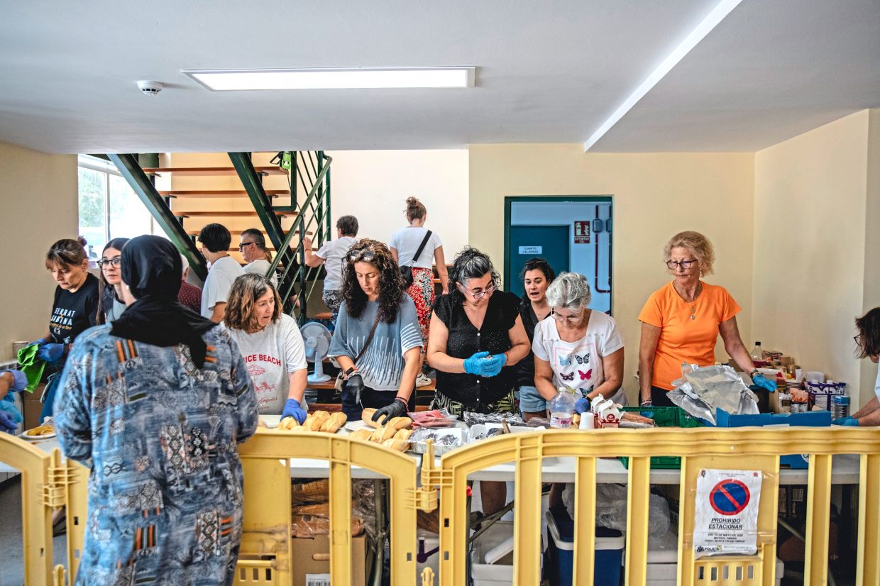 Volunteers prepare lunches an evacuation center in near Villamanta. — Joseph Fox/The New York Times