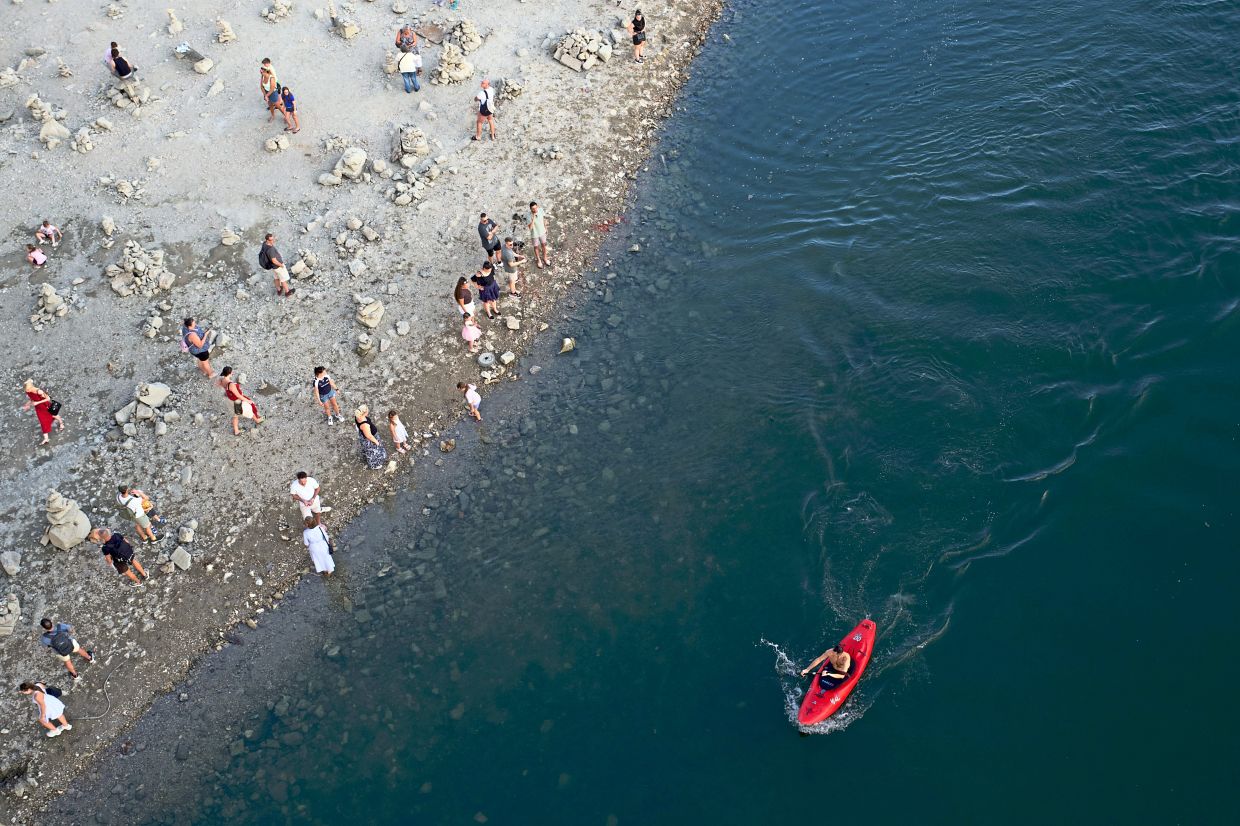5. A kayaker passing a sandbar beneath Margaret Bridge in central Budapest, Hungary, as the Danube recedes to unprecedented low water levels. — AP