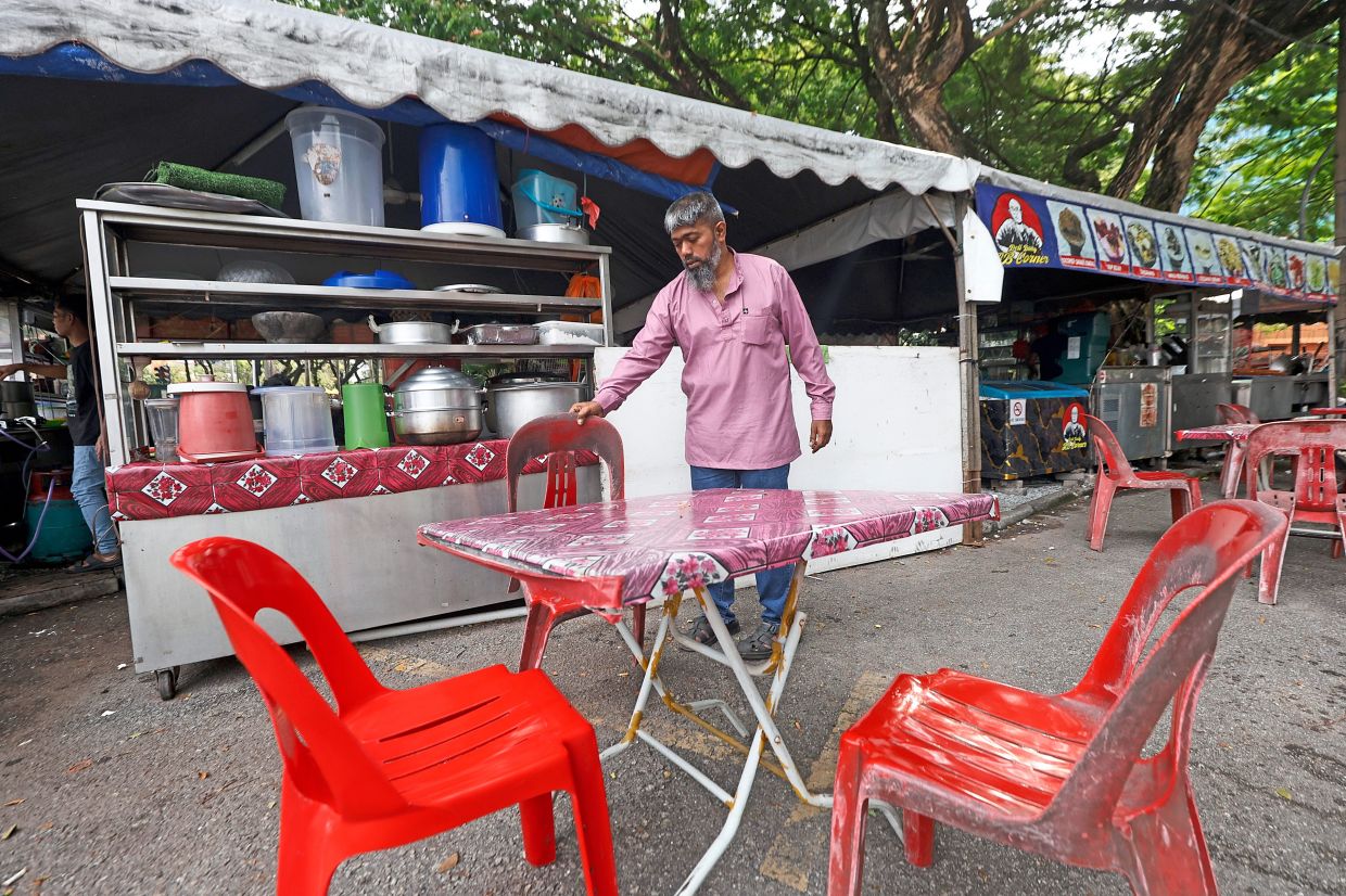Sirajudin arranging tables and chairs at his temporary trading site, after his stall on Jalan 2/27a was demolished to make way for upgrades.
