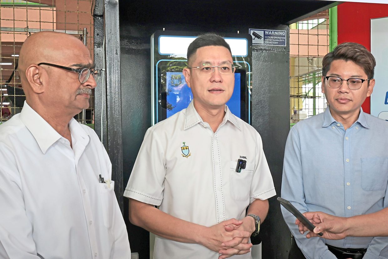 Zairil (centre) with Rajendran (left) and MBPP councillor Lee Seng Hwai at the launch of the self-service payment kiosk at it’s sixth location.