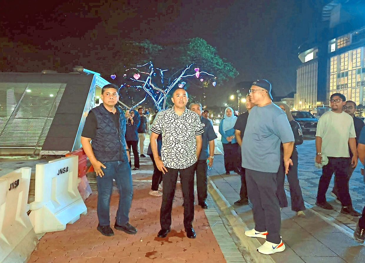 Mohd Jafni (centre) and Mohd Haffiz (left) checking out the upgraded area surrounding the 0km marker in Johor Baru.