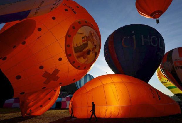 3. Workers preparing hot air balloons ahead of the mass launch. The mass ascent is scheduled twice daily, at approximately 6am and 6pm. — Reuters