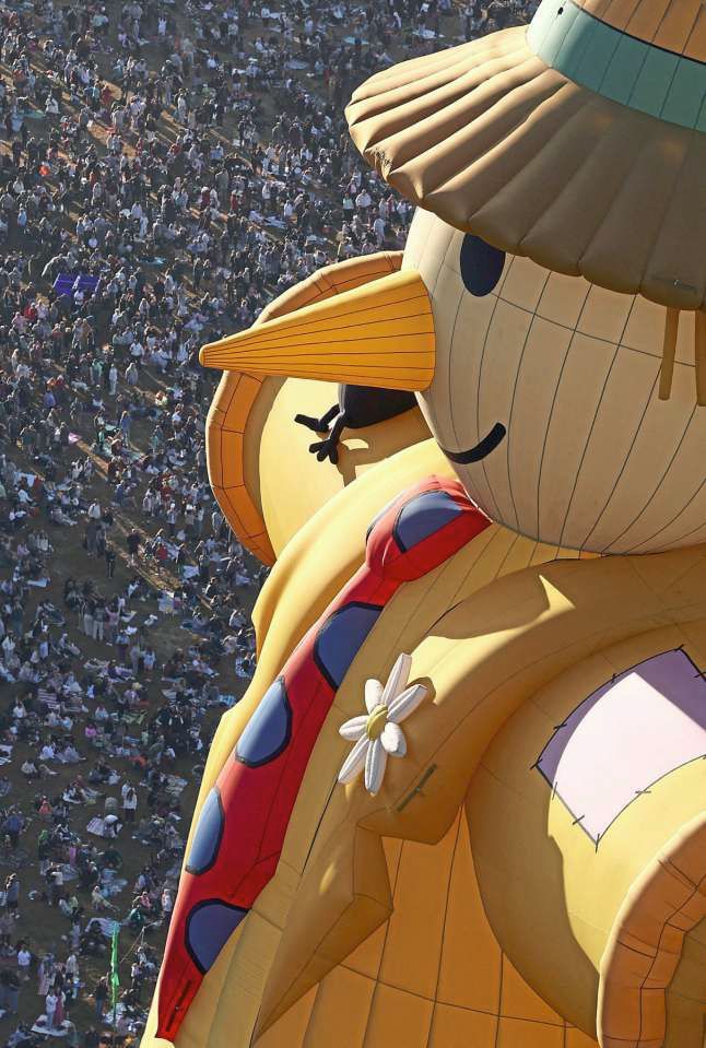 2. Crowds watching a scarecrow-shaped hot air balloon rise during a mass launch. Over the years, many weird and wonderfully shaped balloons have graced the skies, with some becoming regular sights at balloon festivals in the UK and around the world. — Reuters
