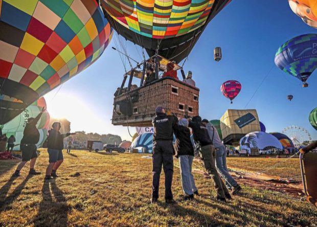 1. Hot air balloon crews pushing balloons into position before lifting off over Bristol. The city is the birthplace of the modern hot air balloon, dating back to 1967, when the Bristol Belle was built and flown in the area. — AP