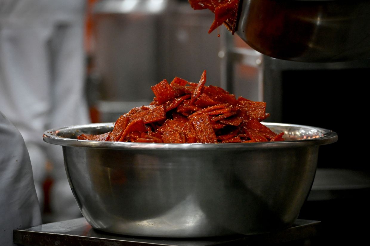 A worker pouring spicy strips into a bowl at a shop in Changsha, in China's central Hunan province.