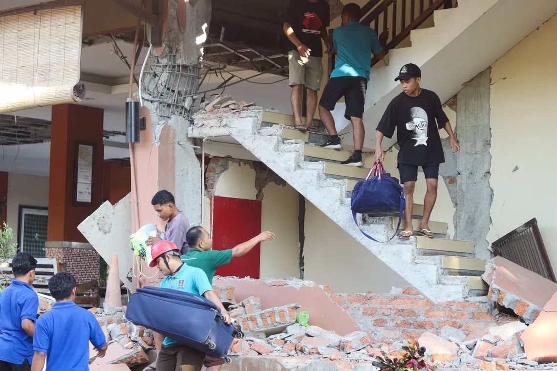 People evacuating from a collapsed Jayakarta hotel following an earthquake in Labuan Bajo, East Nusa Tenggara, on Aug 15. -- PHOTO: REUTERS