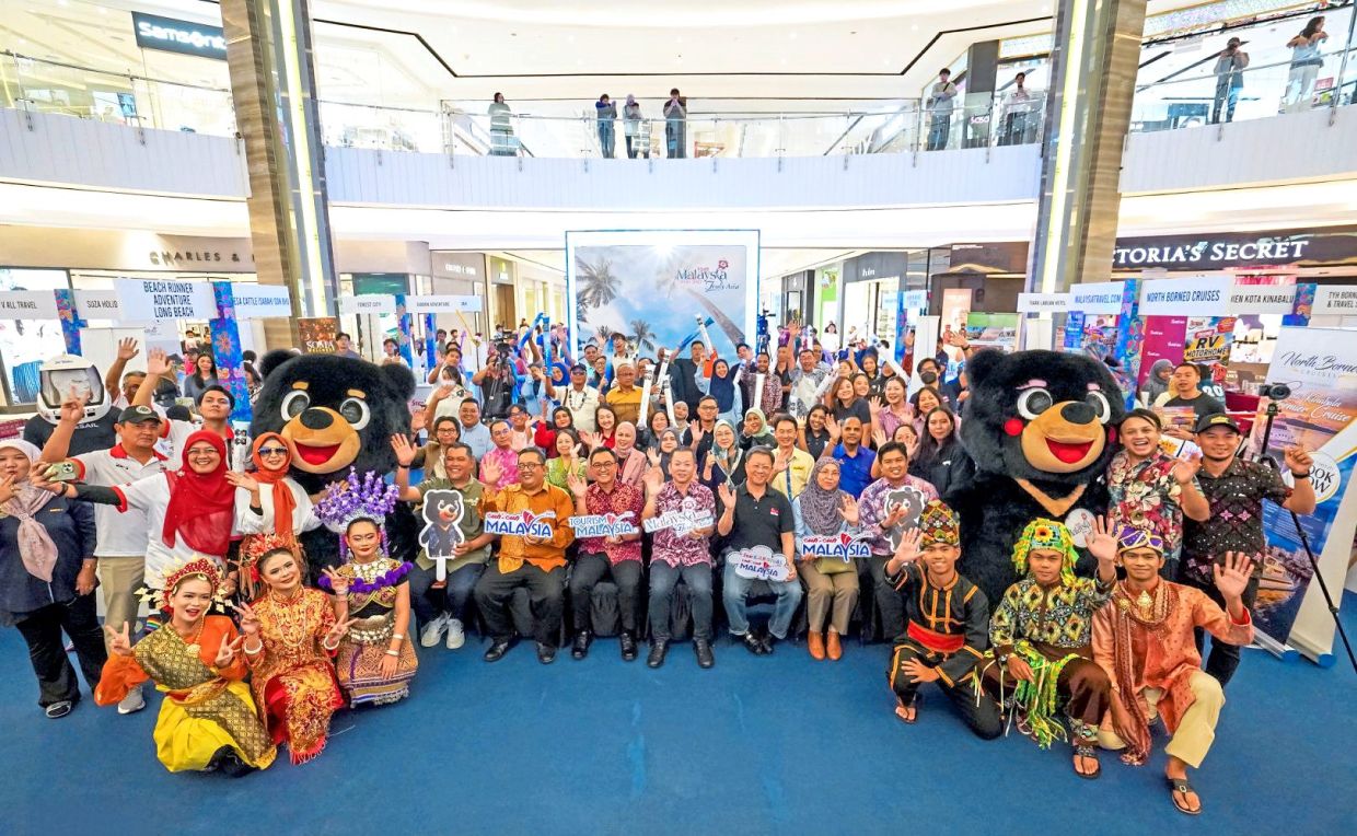 One for the album: Foong Hin (centre), Seng Fatt (third from right) and Wizani (fifth from right) with other attendees during Star Karnival Cuti-Cuti Malaysia 2026 in Kota Kinabalu.