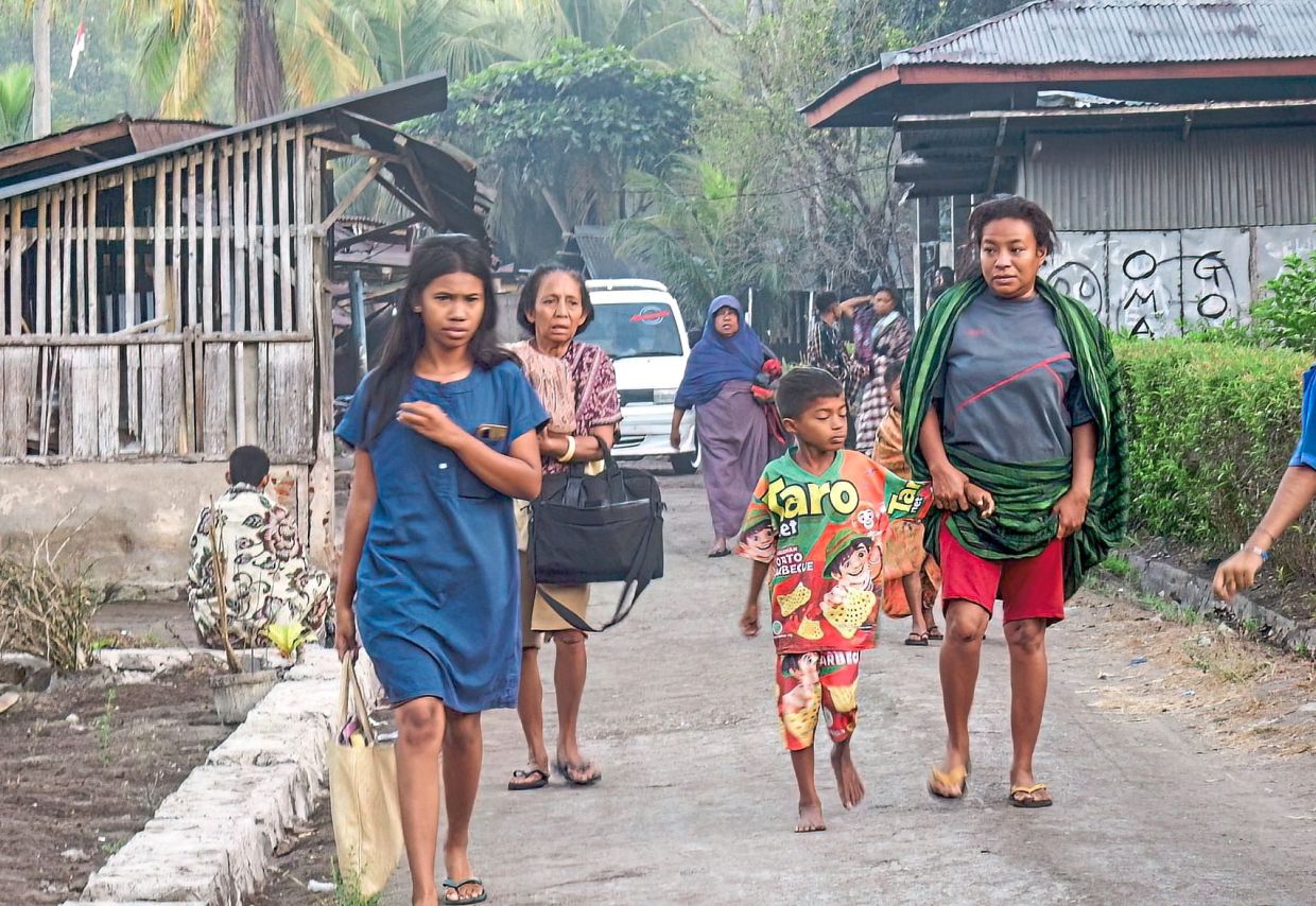 Safety first: Villagers fleeing their homes to seek safety in Talibura village, Sikka, East Nusa Tenggara. (Below) Hospital staff working under a makeshift tent in Labuan Bajo, East Nusa Tenggara province. — AFP/AP