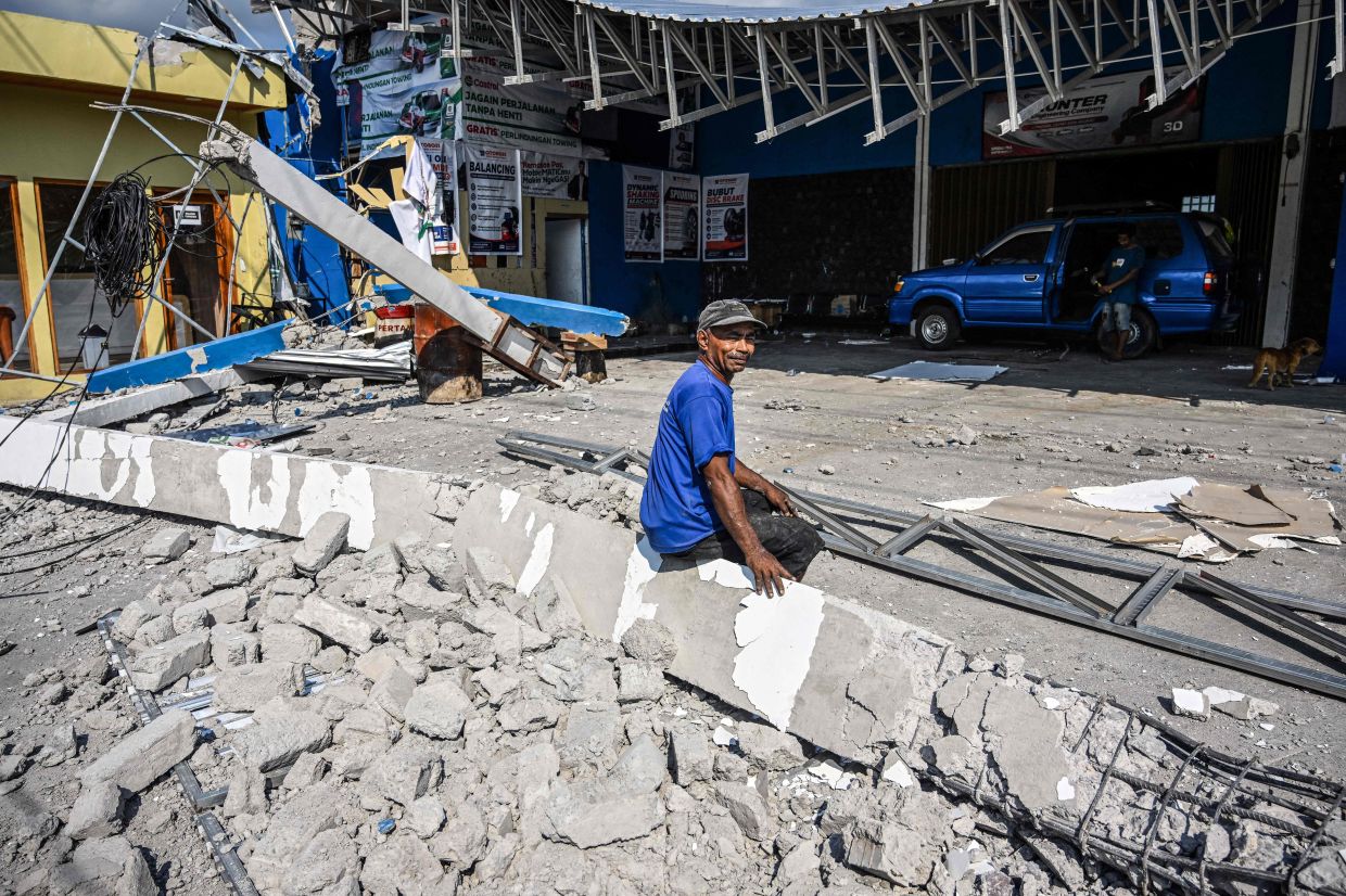 A man sits amid the debris from a damaged building following a 7.7-magnitude earthquake in Borong, East Manggarai, East Nusa Tenggara on Aug 16, 2026. Help started arriving on Aug 16 for thousands of evacuees on Indonesia's Flores island after a powerful earthquake killed over 50 people, injured dozens and damaged hundreds of houses and buildings. - Photo: AFP